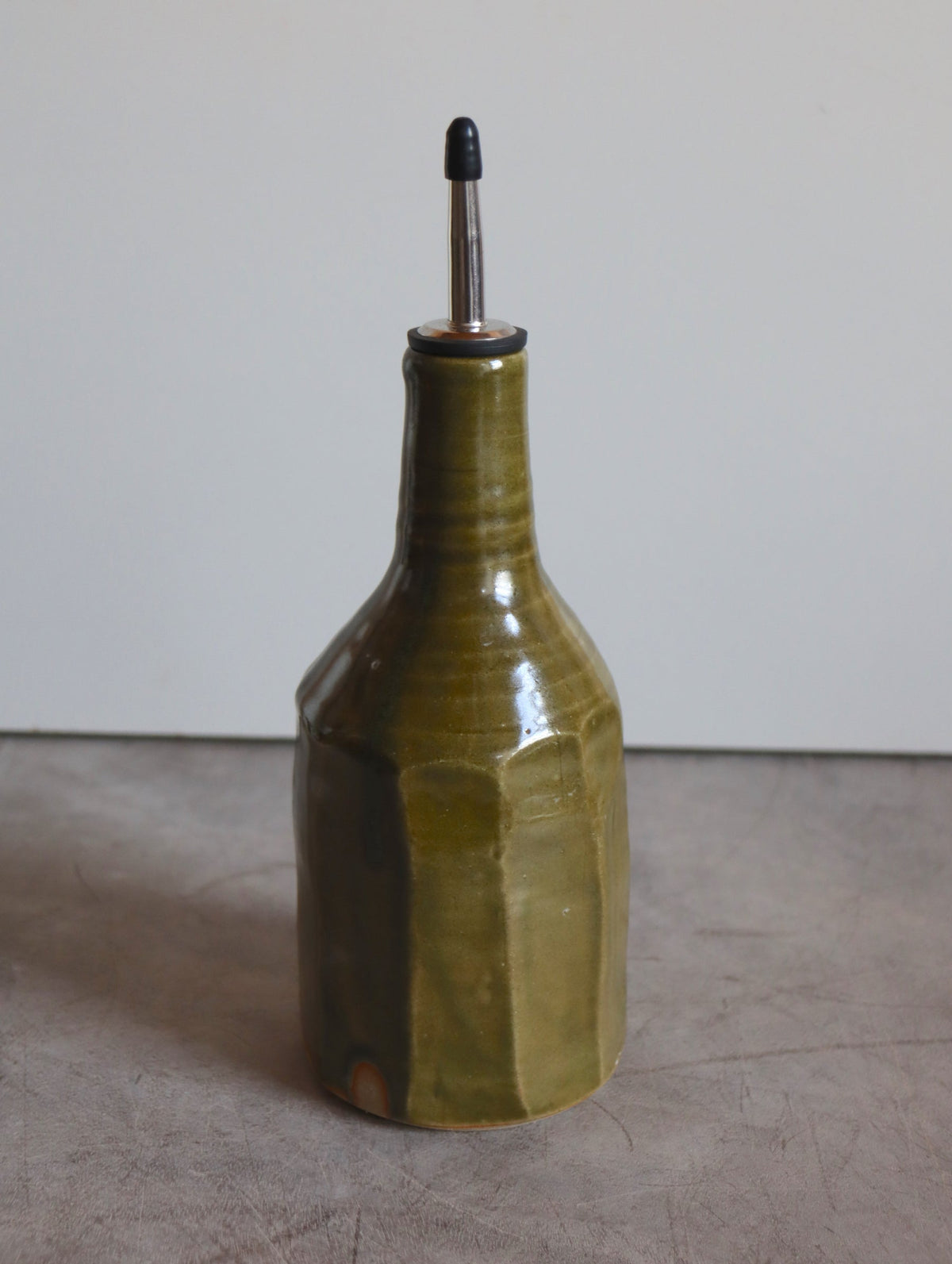 Faceted large oil pourer in moss green glaze with a steel pouring spout